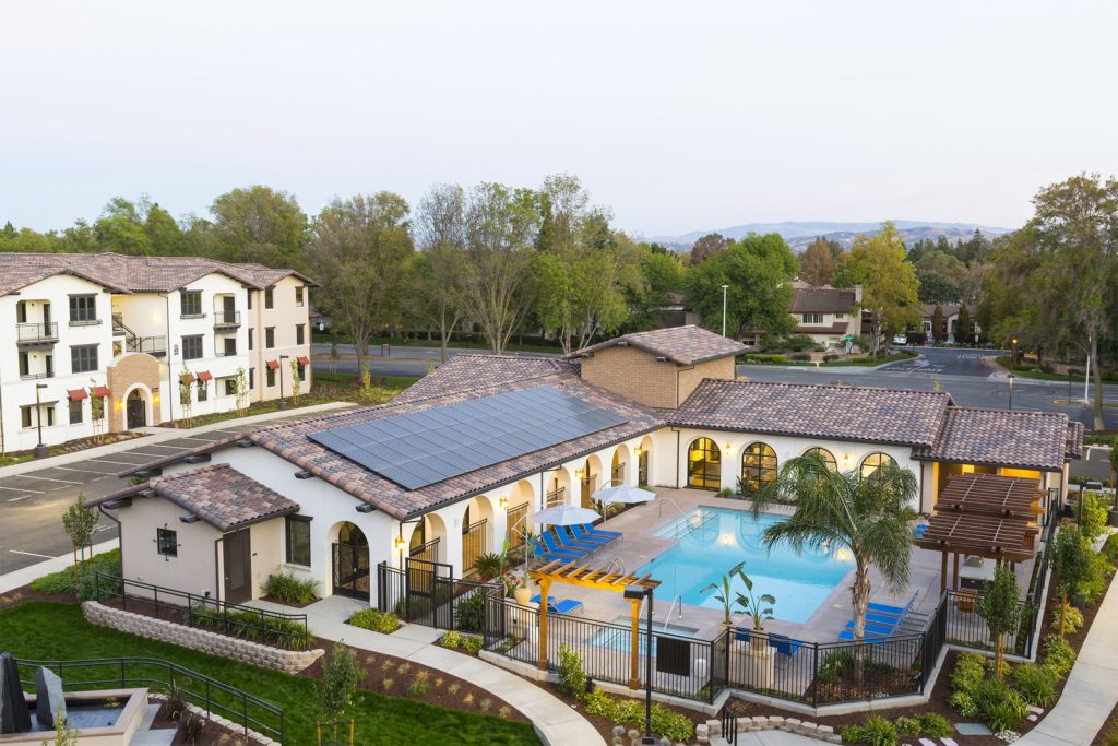 Commercial property with a large solar panel on one roof overlooking a pool